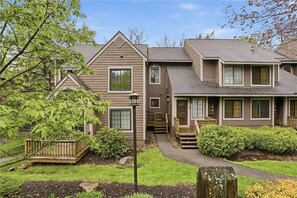 A two-story house with a front porch, a covered entryway, and a landscaped yard. - Cozy and quiet 2 bedroom condo at Hidden Valley (Hidden Valley)