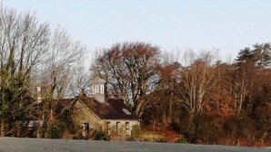 A building with a traditional architectural style, surrounded by trees and a clear sky. - The Escape, beautiful country estate cottage (Y Felinheli)