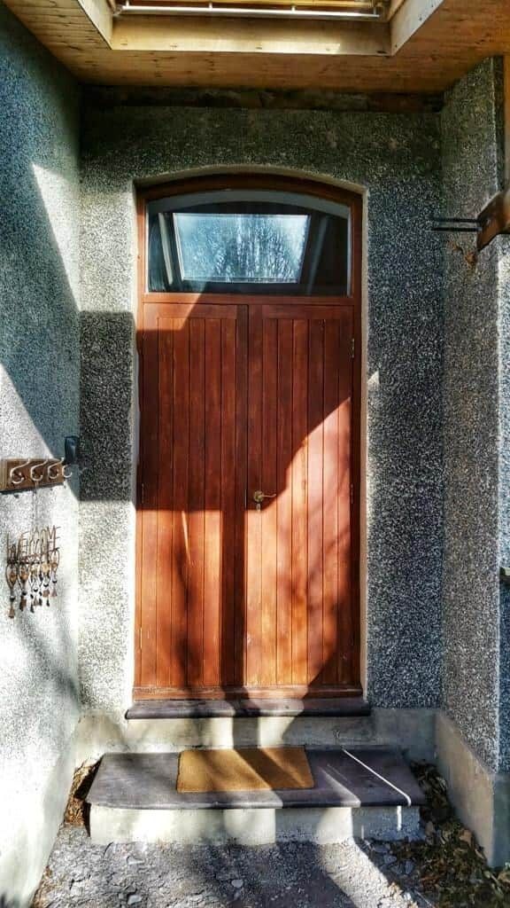 A wooden door with a small overhang, set in a stone wall.