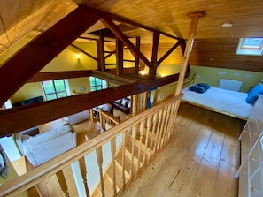 Un intérieur en bois avec un escalier, un canapé et une fenêtre.
