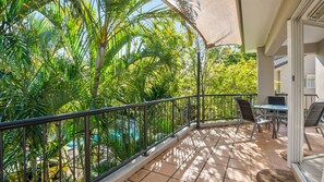 A balcony with a metal railing, outdoor furniture, and lush greenery. - Sanctuary Lake Apartment 67 - Beachside Oasis in Currumbin - Min. 3 Night Stays - Linen Provided (Currumbin)