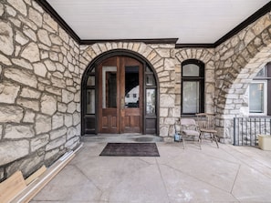 A stone facade with a wooden door and arched windows.