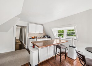 A modern kitchen with white cabinetry, a granite countertop, and a window providing natural light.