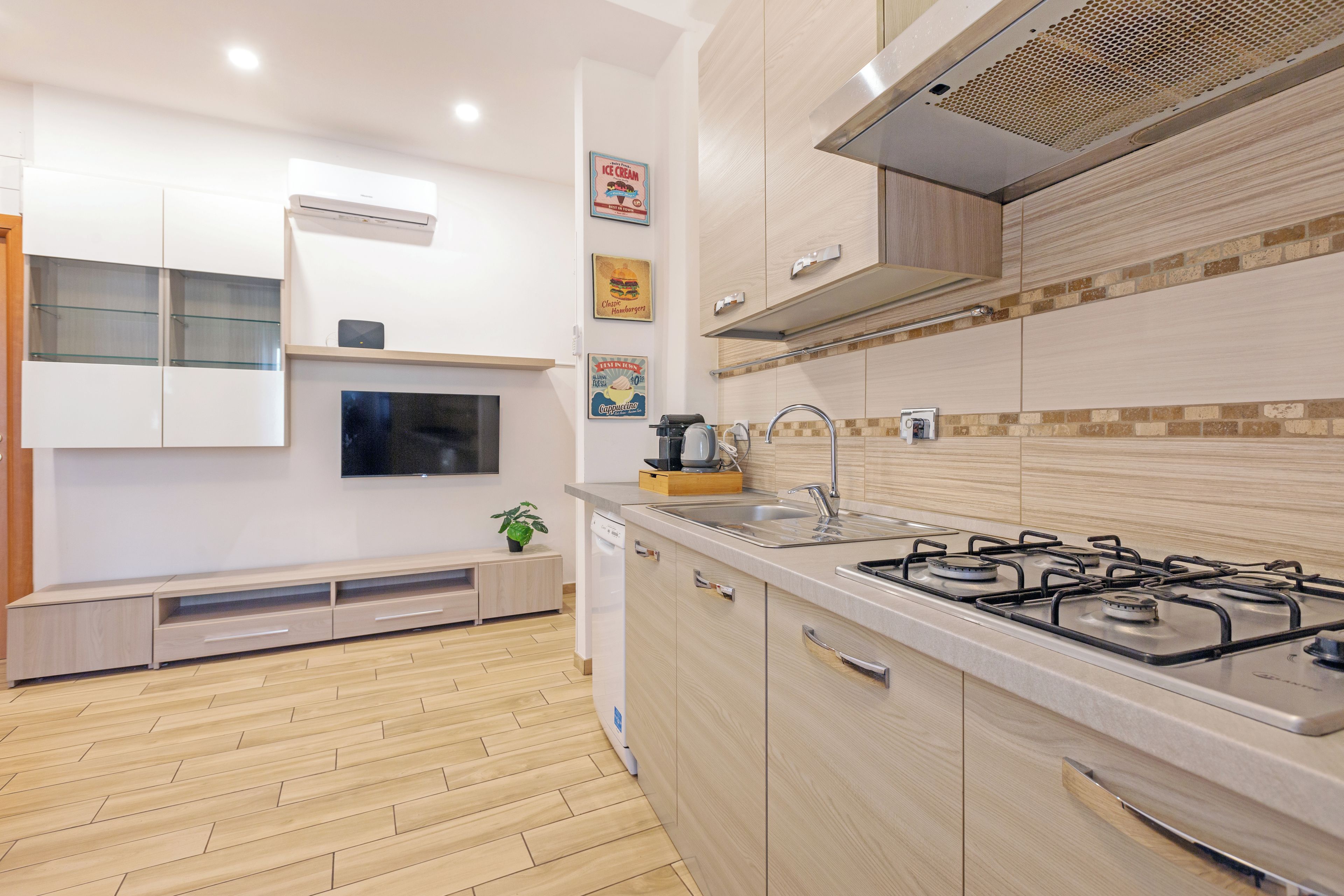 Una cocina moderna con estufa a gas, lavavajillas y horno empotrado.