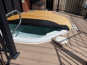 A hot tub with a wooden deck, a metal railing, and a sign indicating a 3-foot clearance. - True Ski-in Ski-out at Solitude - with pool and hot tub (Brighton)