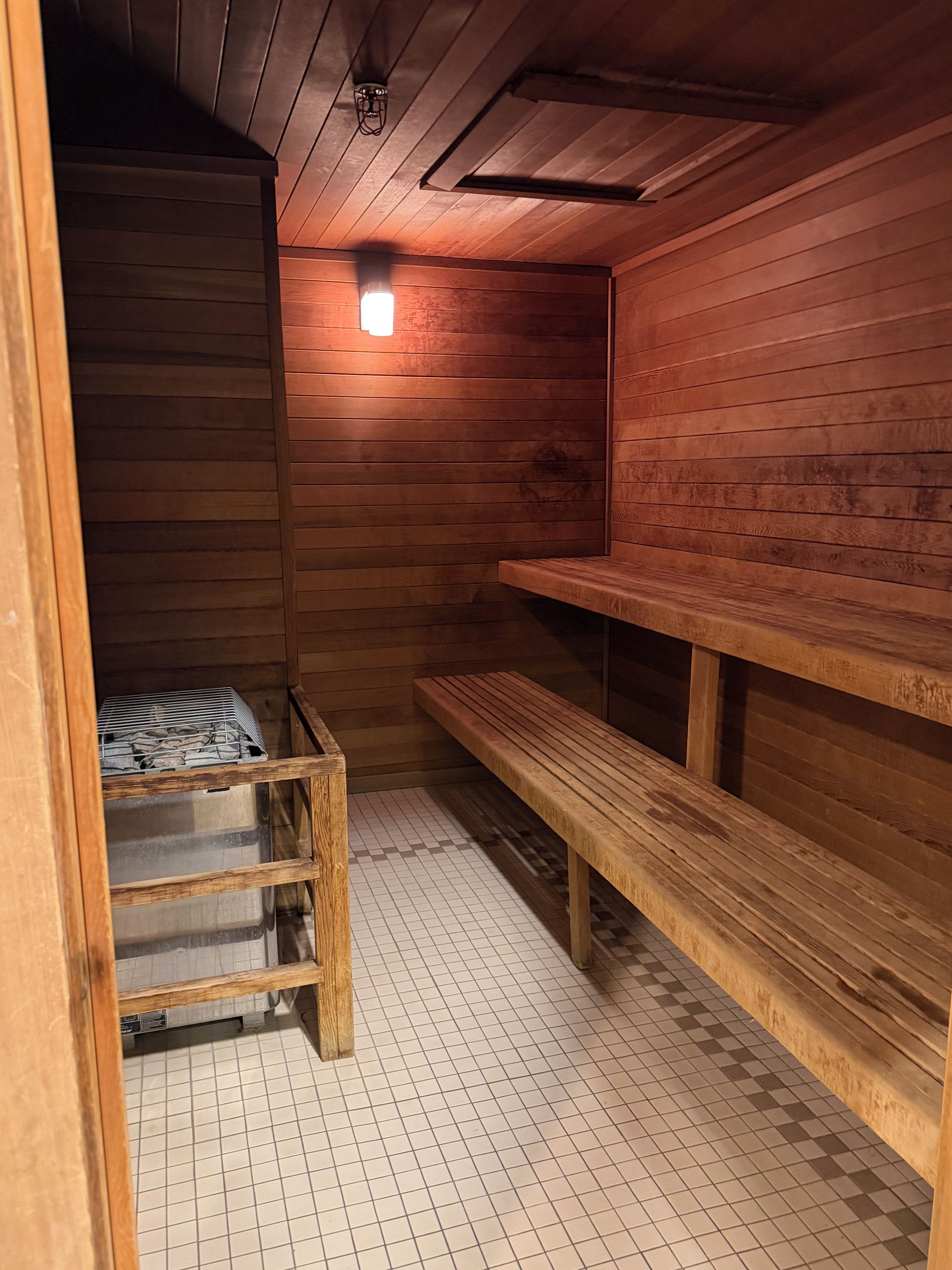 A sauna room with wooden benches and a bench with a towel.