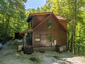 A wooden cabin with a porch, a stone foundation, and a gravel driveway. - Nantahala Adventures- Hot tub- Firepit- Foosball Table (Bryson City)