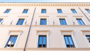 A multi-story building with a symmetrical facade, evenly spaced windows, and a central entrance. - Numa Rome Via Veneto (Roma)