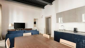 Una sala moderna con un sofá, un televisor y una mesa de comedor de madera.