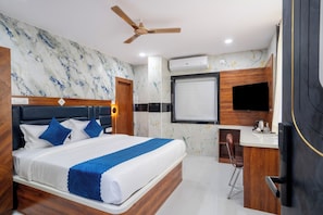 Une chambre d’hôtel moderne équipée d’un grand lit, d’un bureau, d’un ventilateur de plafond et d’un appareil de climatisation.