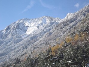 A mountain with snow-covered slopes and sparse vegetation.