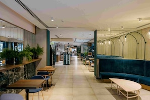 A modern interior with a long corridor, seating areas, and a bar.