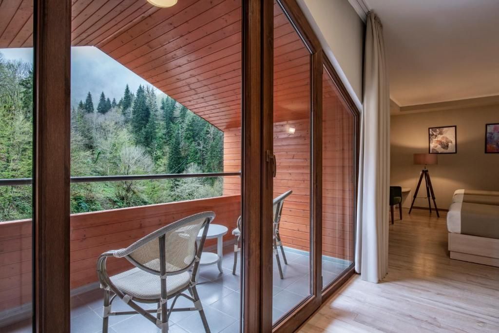 Un interior moderno con un balcón con vistas a una zona boscosa.