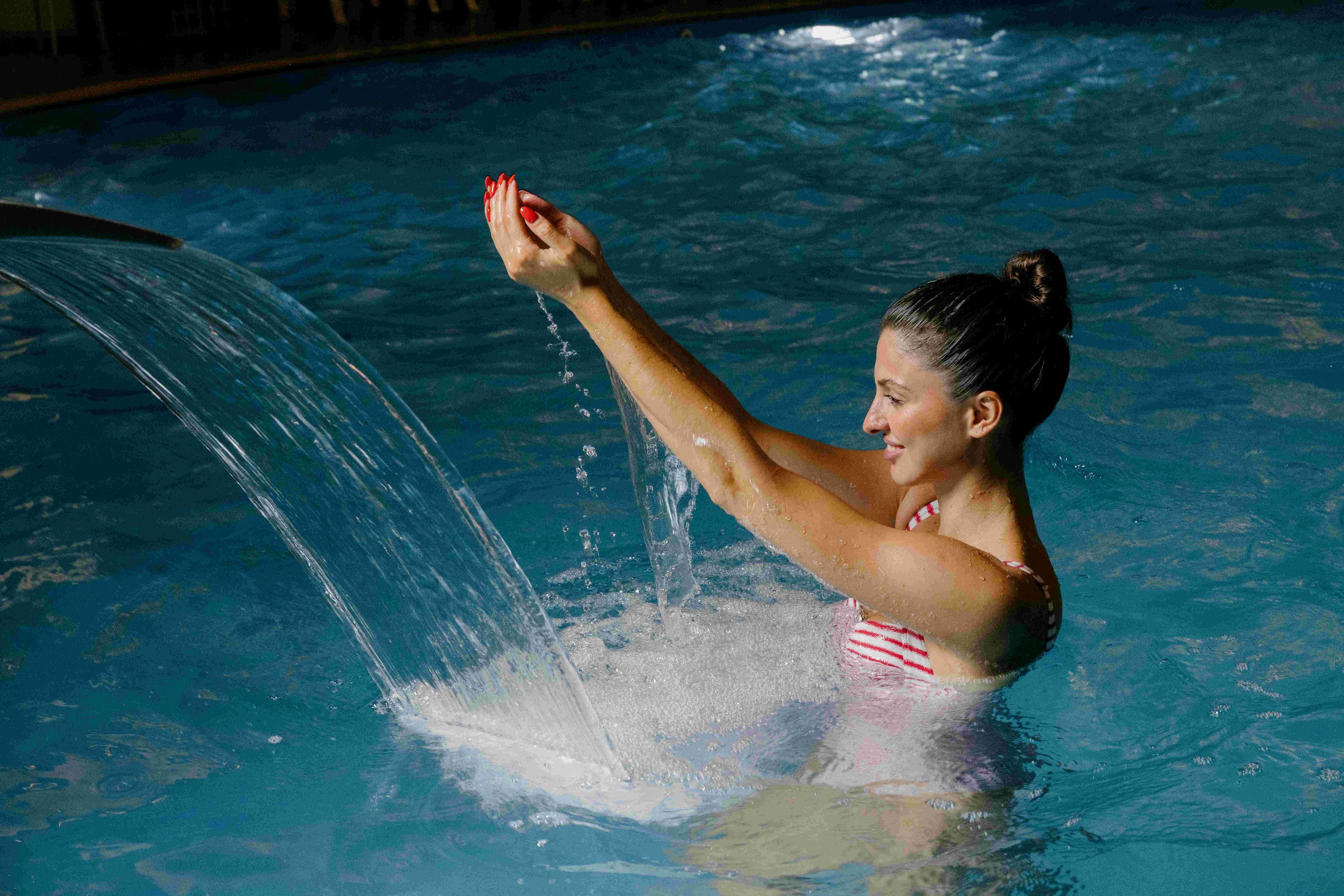 A person in a swimming pool with water splashing around them.