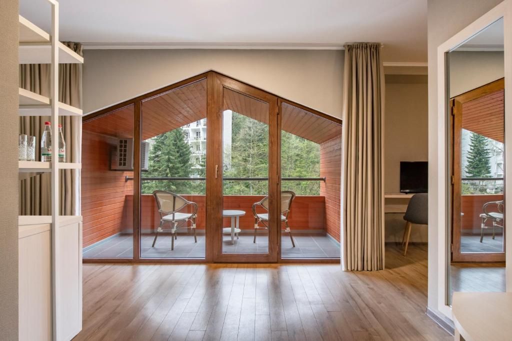 Un interior moderno con techo de madera, un balcón con sillas y un escritorio con computadora.