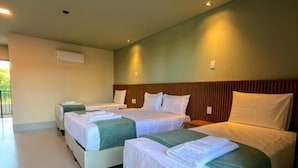 A hotel room with two beds, a wooden headboard, and a large window. - Essence Paradise Pousada Charme  (Bonito)