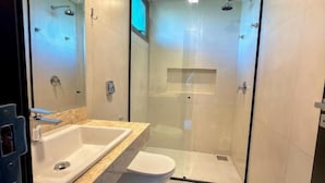 A modern bathroom with a glass-enclosed shower, a white sink, and a toilet. - Essence Paradise Pousada Charme  (Bonito)