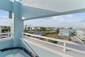 A balcony with a view of a residential area, including houses and a body of water. - 🌞Salty Seahorse 100 | Heated Pool | New Build 🌴 (Fort Myers Beach)