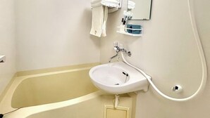 A bathroom with a bathtub, a sink, a mirror, and a towel rack. - TOGA HOTEL Showamachi (Kita-ku)