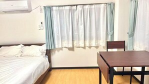 A room with a bed, a table, and a chair. There is a window with curtains. - TOGA HOTEL Showamachi (Kita-ku)