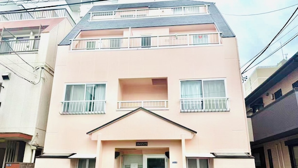 A two-story building with a flat roof, a central entrance, and a small balcony on the upper floor. - TOGA HOTEL Showamachi (Kita-ku)