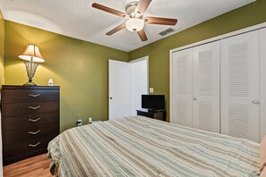 A bedroom with a bed, dresser, ceiling fan, and wardrobe. - Cozy 2-bedroom house in welcoming Seminole with AC (Seminole)