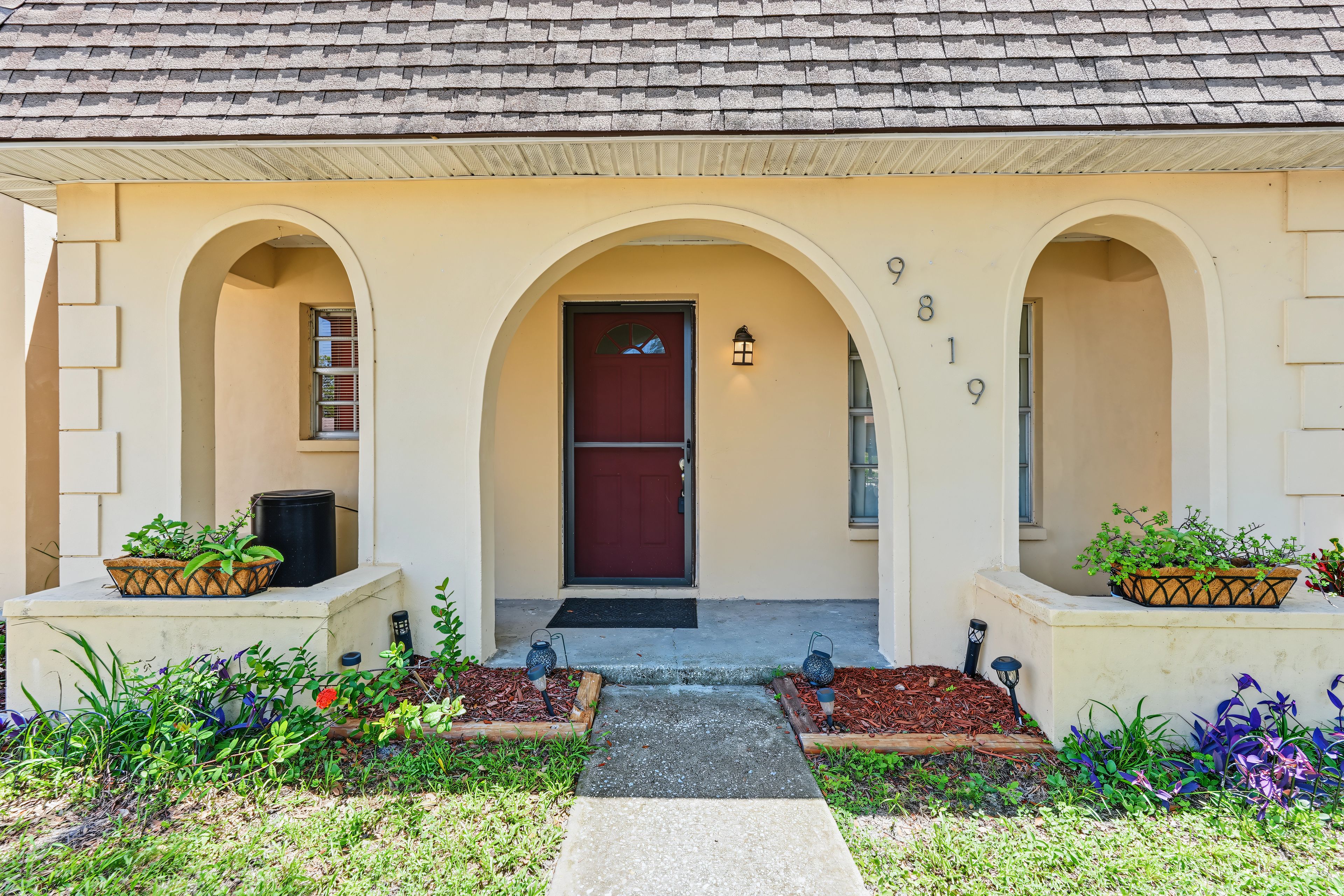 A building with a central entrance, arched doorways, and numbered windows.