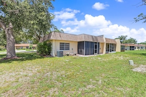 A residential building with a sloped roof, large windows, and a lawn in front. - Cozy 2-bedroom house in welcoming Seminole with AC (Seminole)