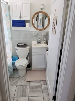 Ein kleines Badezimmer mit Toilette, Waschbecken und Spiegel.