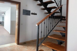 A staircase with wooden steps and black balusters, leading to an upper floor. - Apartment for Couples in Valleseco (Valleseco)