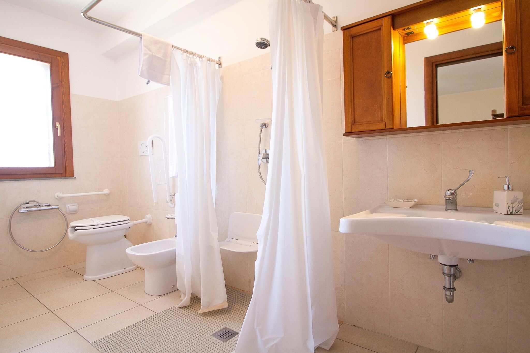 A bathroom with a toilet, bidet, shower, and sink.