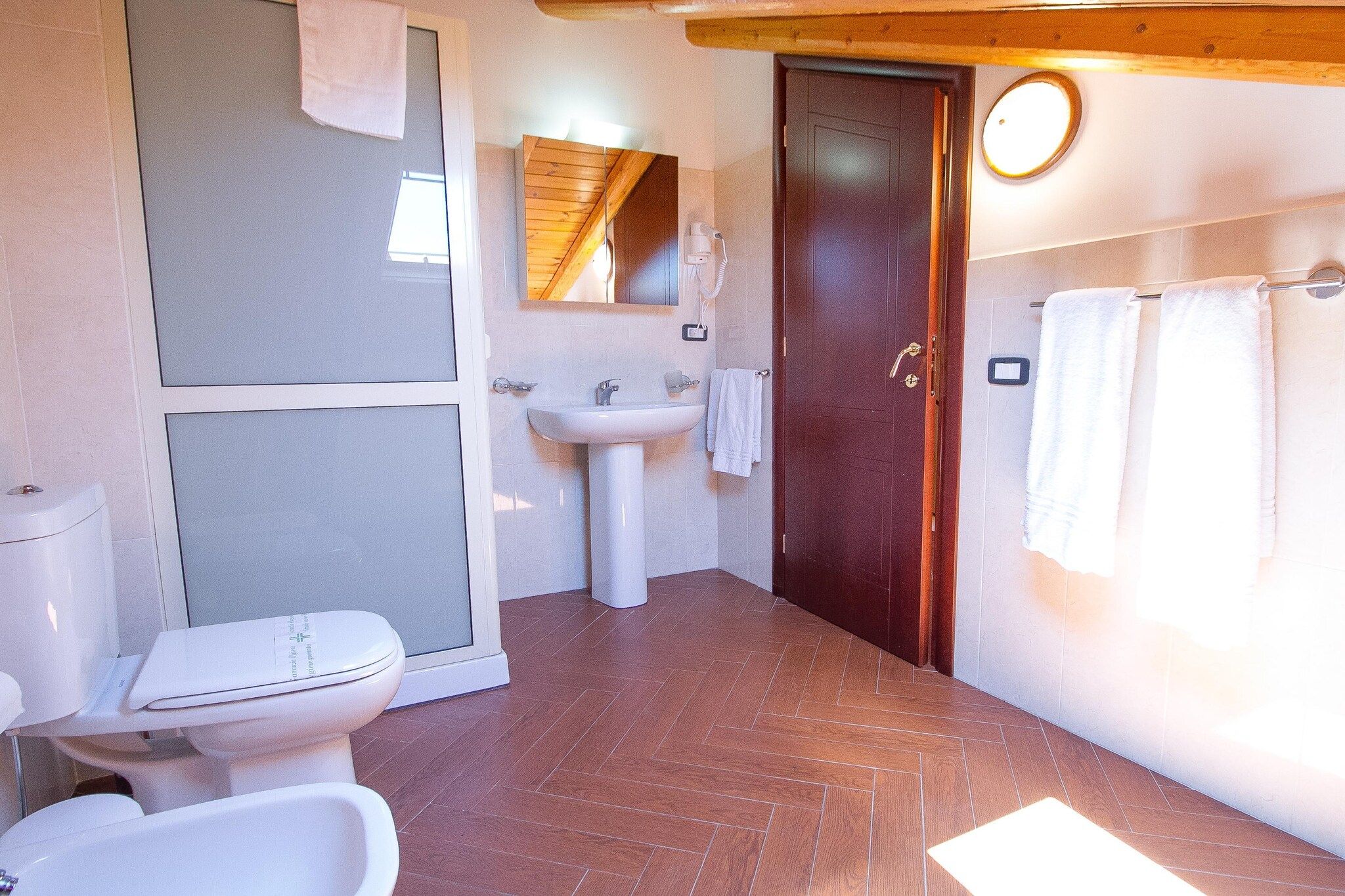 Ein Badezimmer mit Toilette, Waschbecken und Duschbereich.