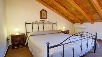 A bedroom with a bed, nightstands, and a wooden ceiling.