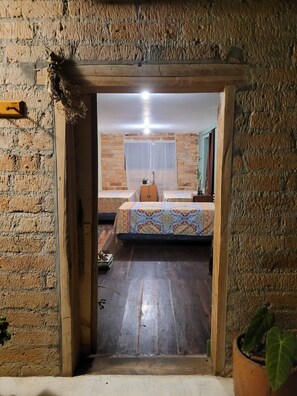 A room with a bed, a small table, and a potted plant. - House for 10 in an oak Forest Santa Elena (Medellín)