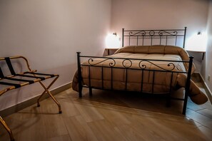 Un dormitorio con una cama, una silla y una mesita de noche.