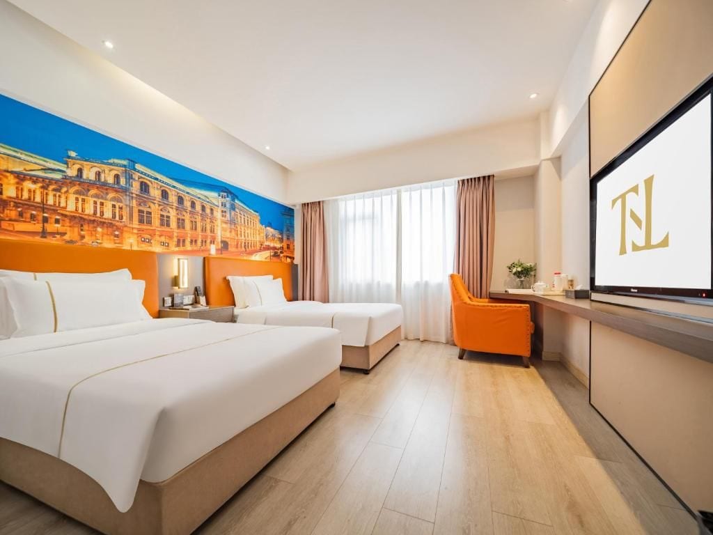 Habitación de hotel con dos camas, un televisor y un mural con vista a la ciudad.