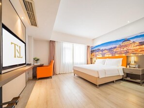 Una habitación de hotel con una cama, un escritorio, una silla y un mural grande en la pared.