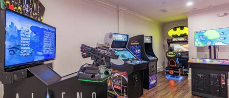 A gaming arcade with various arcade machines, including titles like 'ALIENS' and 'Batman'.