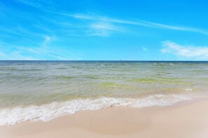 A beach with clear water and a sandy shore. - 🏖️ Beachfront Salt and Grace: Direct Gulf Access + Balcony + Dog Friendly (Fort Morgan)
