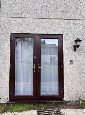 A double door with glass panels, a metal handle, and a number '56' on the door frame.