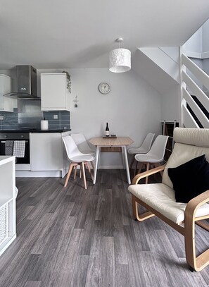A modern kitchen with white cabinets and a dining area with a wooden table and chairs.