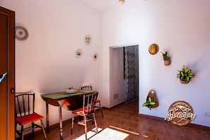 Ein Essbereich mit Tisch, Stühlen und dekorativen Tellern an der Wand.