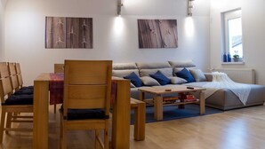 A modern living room with a sofa, two chairs, a coffee table, and artwork on the walls. - Vrbo Property (Ettenheim)