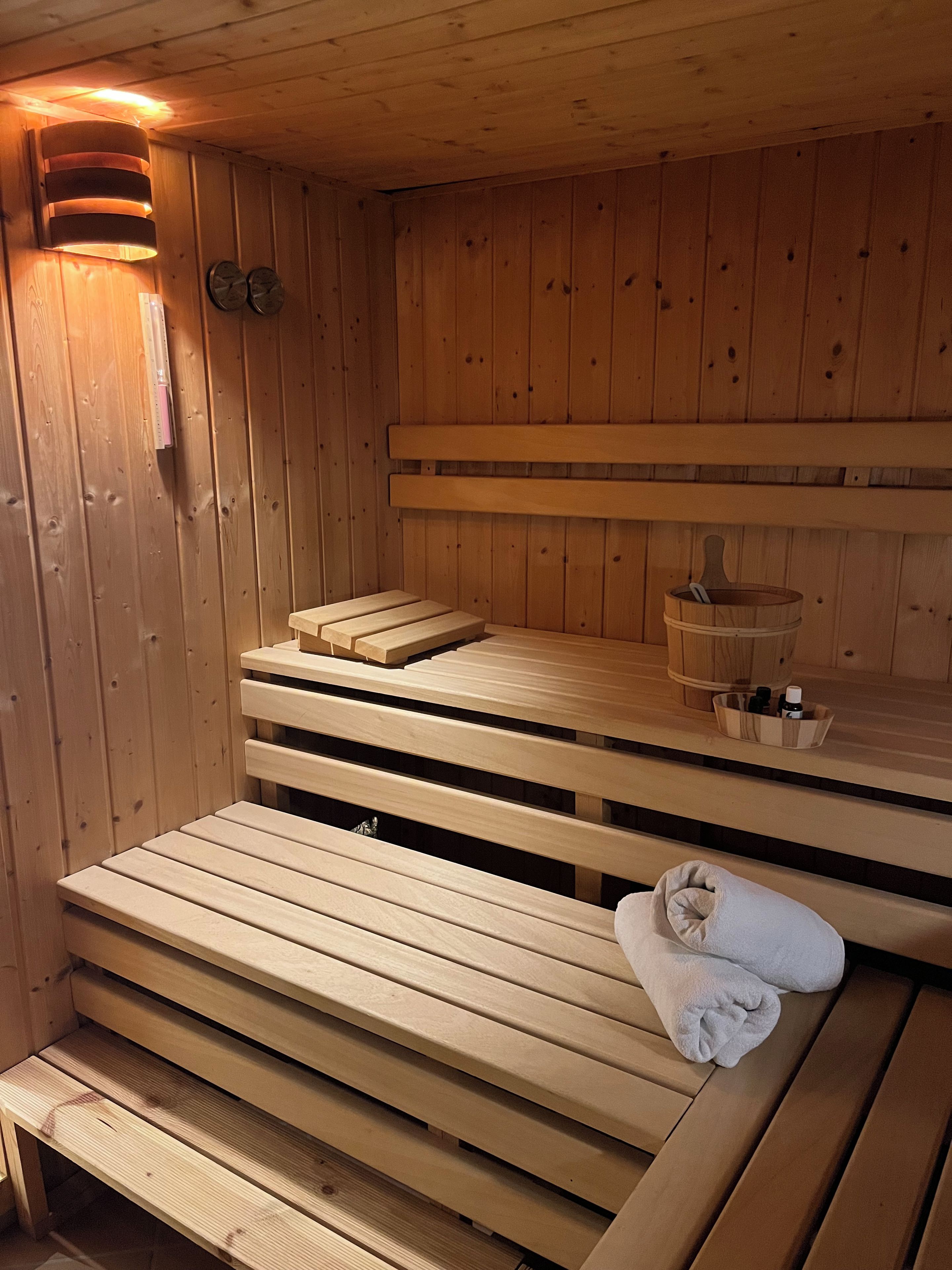 A wooden sauna with benches and a towel on one of them.