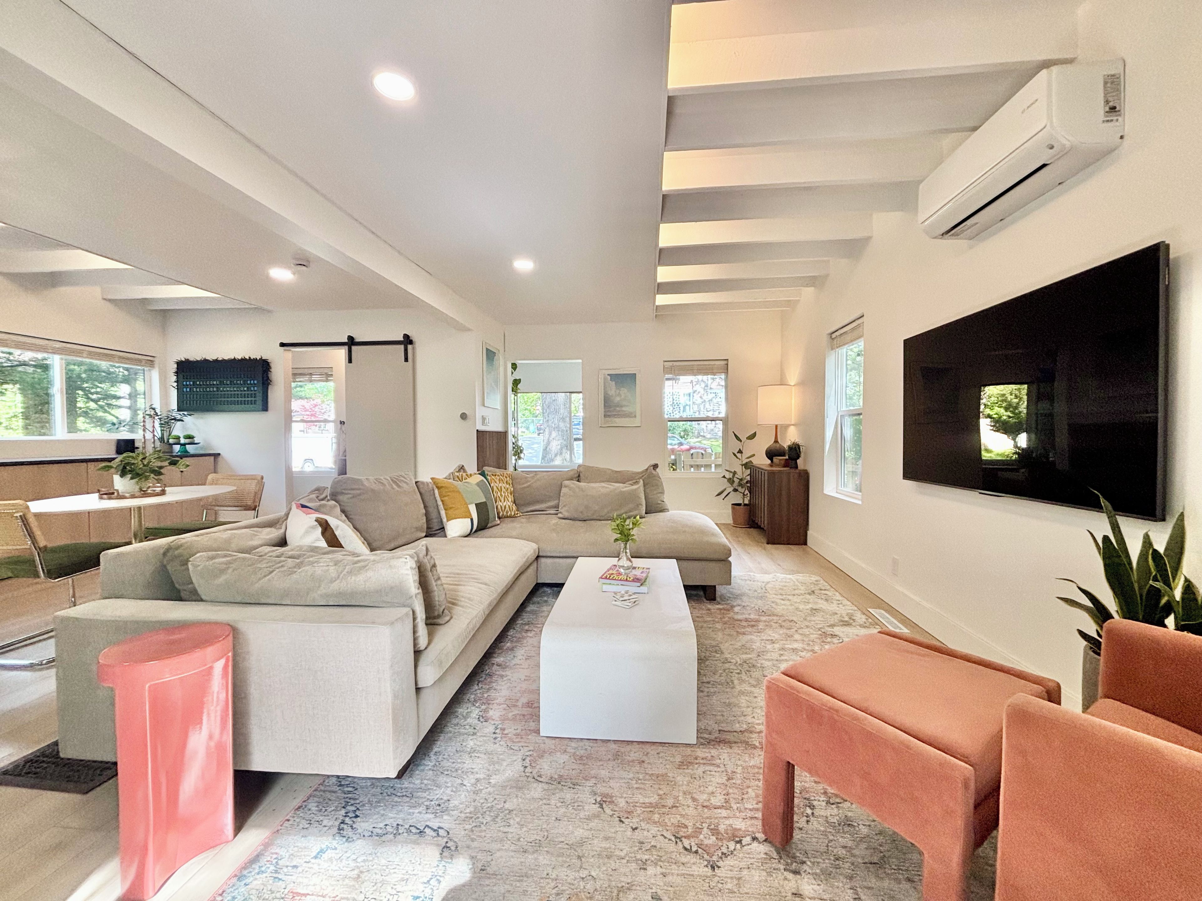 A modern living room with a sofa set, a coffee table, and a television mounted on the wall.