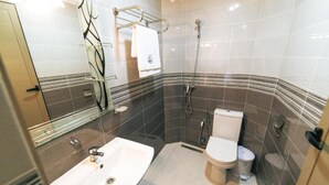 Une salle de bain moderne avec un lavabo blanc, des toilettes et une douche.