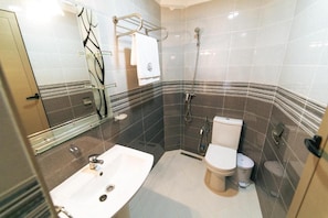 Ein modernes Badezimmer mit einem weißen Waschbecken, einer Toilette und einer Dusche.