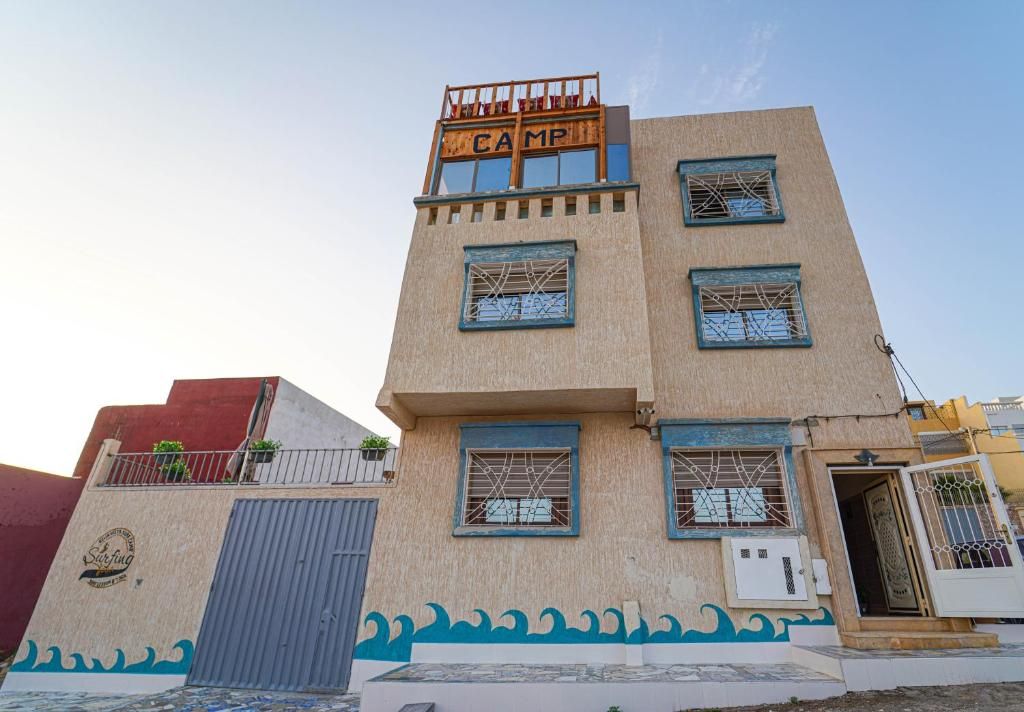 A multi-story building with a sign reading 'CAMP' on the top.