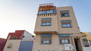 Un immeuble à plusieurs étages, sur lequel on peut lire l’inscription « CAMP » en haut.