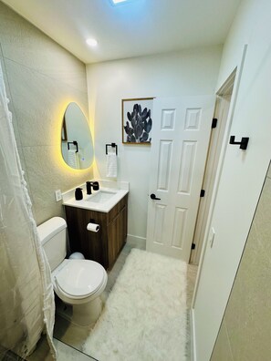 A bathroom with a toilet, sink, and mirror. - Cozy 1-bedroom apartment in fantastic Fort Lauderdale with AC (Fort Lauderdale)